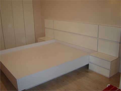 Мебель для спальниБольшая кровать с глянцевыми панелями.