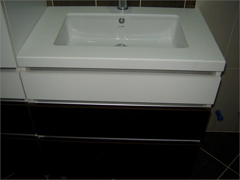 Мебель для ваннойНебольшой керамический умывальник в акриловой столешнице.